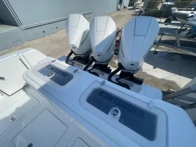 Slide: The Image of 2025 Contender 35 ST boat with triple outboard engines, docked outdoors. - 5
