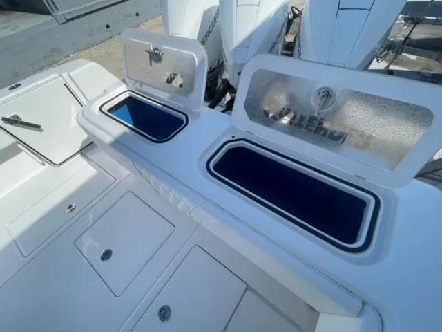 Slide: The Image of 2025 Contender 35 ST boat with open storage compartments and visible outboard engines. - 6