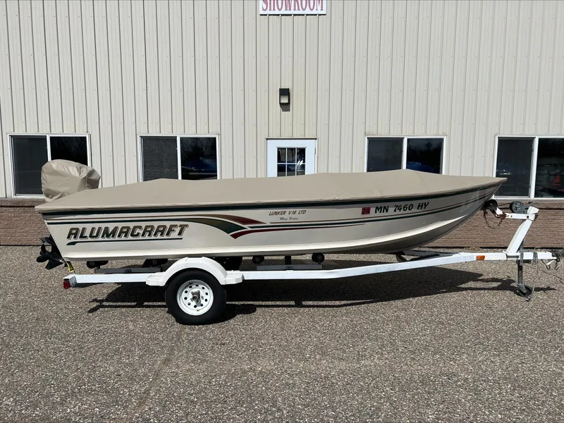 Slide: The Image of 2000 Alumacraft V 16 LTD boat on trailer, parked outside a building. - 2