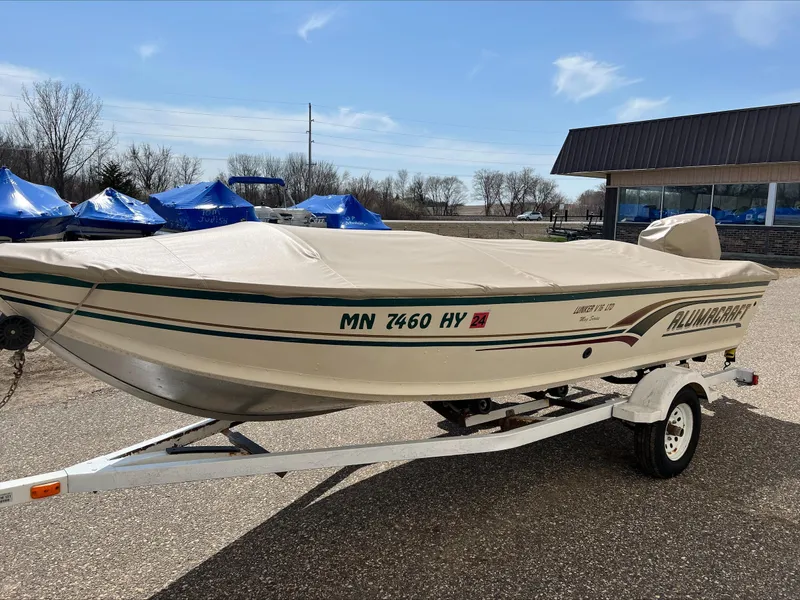 Slide: The Image of 2000 Alumacraft V 16 LTD boat on trailer, covered, parked outdoors. - 3
