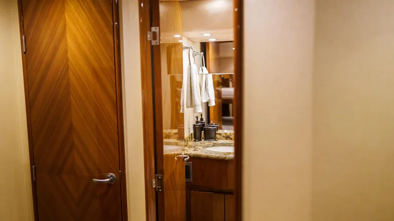 Slide: The Image of Interior of 2012 Viking 70 Enclosed Bridge yacht bathroom with wooden door and granite countertop. - 27