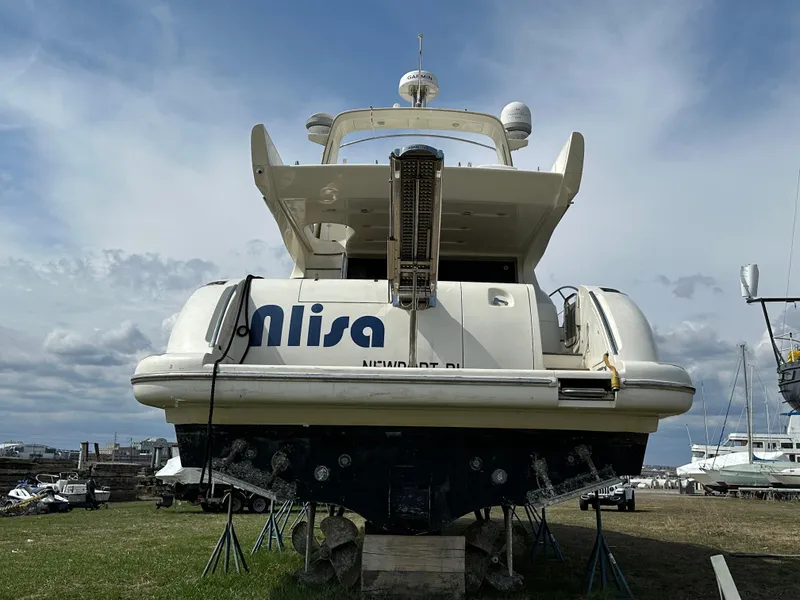 Slide: The Image of 2008 Azimut 62 Evolution yacht on stands, rear view, under a cloudy sky. - 11