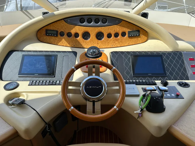 Slide: The Image of Cockpit of 2008 Azimut 62 Evolution yacht with advanced navigation controls and wooden steering wheel. - 19