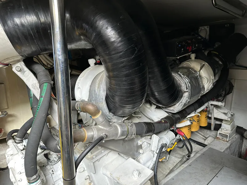 Slide: The Image of Engine room of a 2008 Azimut 62 Evolution yacht, showcasing mechanical components and hoses. - 26