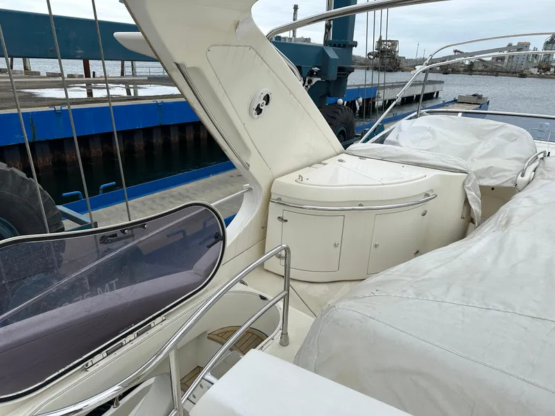 Slide: The Image of 2008 Azimut 62 Evolution yacht deck with covered seating and storage, docked at a marina. - 4