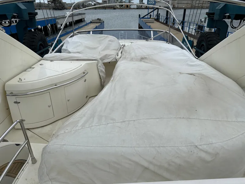 Slide: The Image of 2008 Azimut 62 Evolution yacht deck with covered seating and storage, docked at marina. - 5