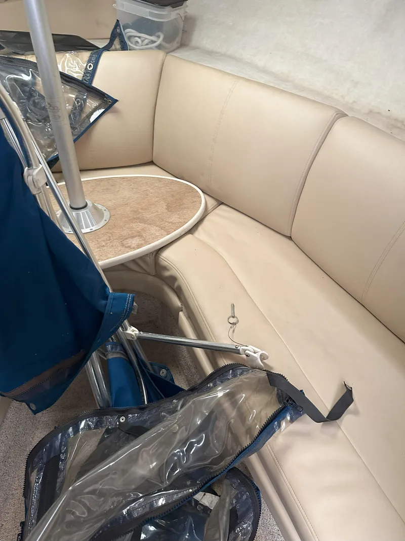 Slide: The Image of 2005 Bayliner 245 CIERA interior with beige seating and table, featuring blue accessories. - 13