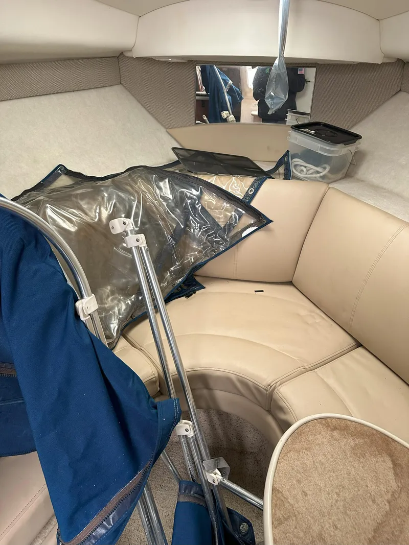 Slide: The Image of Interior of 2005 Bayliner 245 CIERA boat with beige seating and blue accessories. - 14