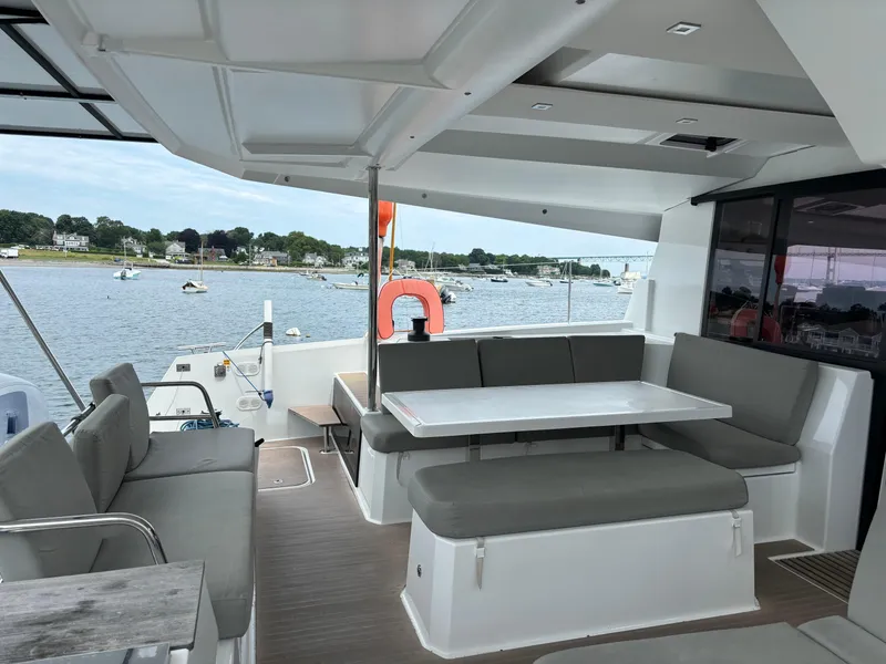 Slide: The Image of Spacious deck of 2022 Fountaine Pajot Astrea 42 catamaran with seating and table, overlooking water. - 4