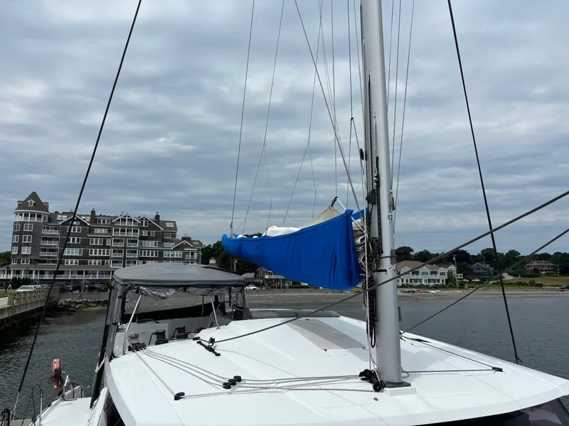 Slide: The Image of 2022 Fountaine Pajot Astrea 42 catamaran docked near coastal buildings under cloudy sky. - 7