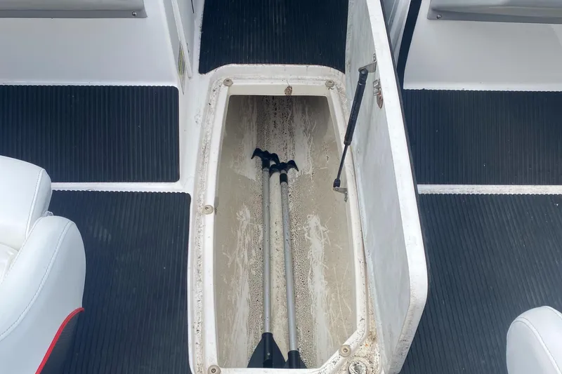 Slide: The Image of 2006 Yamaha Boats SX230 HO storage compartment with paddles inside. - 15