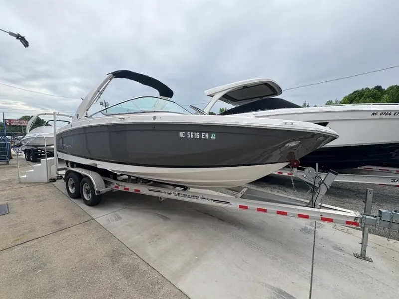 Slide: The Image of 2018 Regal 26 FasDeck boat on trailer, gray and white, parked outdoors. - 1