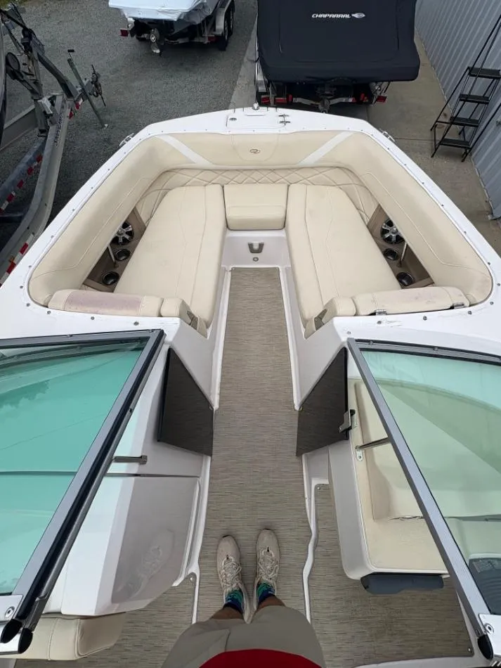 Slide: The Image of 2018 Regal 26 FasDeck boat interior with beige seating and open windshield. - 12