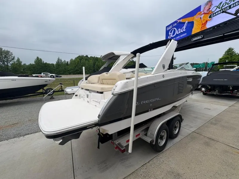 Slide: The Image of 2018 Regal 26 FasDeck boat on trailer, parked outdoors, showcasing sleek design. - 4