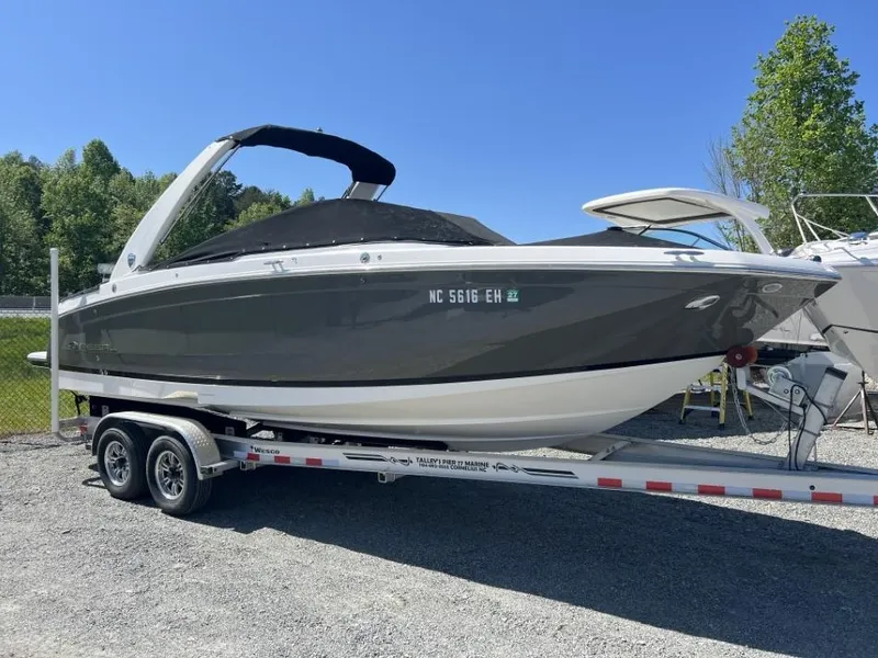 Slide: The Image of 2018 Regal 26 FasDeck boat on trailer, parked outdoors under clear blue sky. - 8