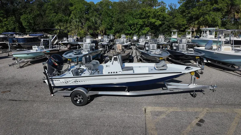 Slide: The Image of 2025 Xpress H20B boat on trailer, surrounded by other boats in a lot. - 11
