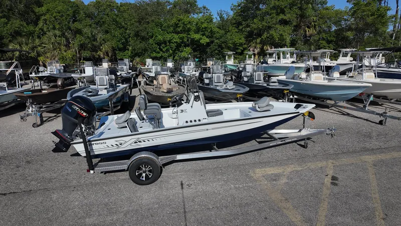 Slide: The Image of 2025 Xpress H20B boat on trailer in marina with multiple boats. - 14