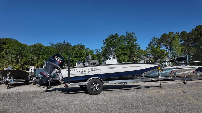 Slide: The Image of 2025 Xpress H20B boat on trailer, parked outdoors under clear blue sky. - 15