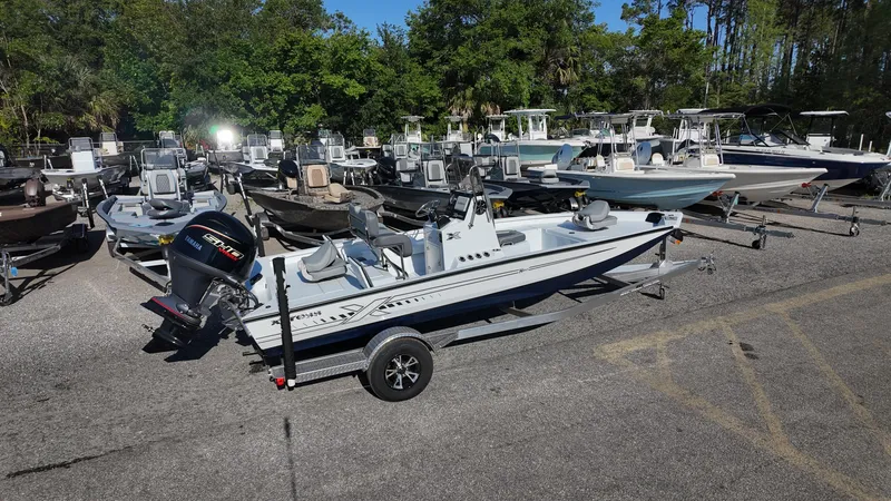 Slide: The Image of 2025 Xpress H20B boat in a dealership lot, surrounded by various other boats. - 17