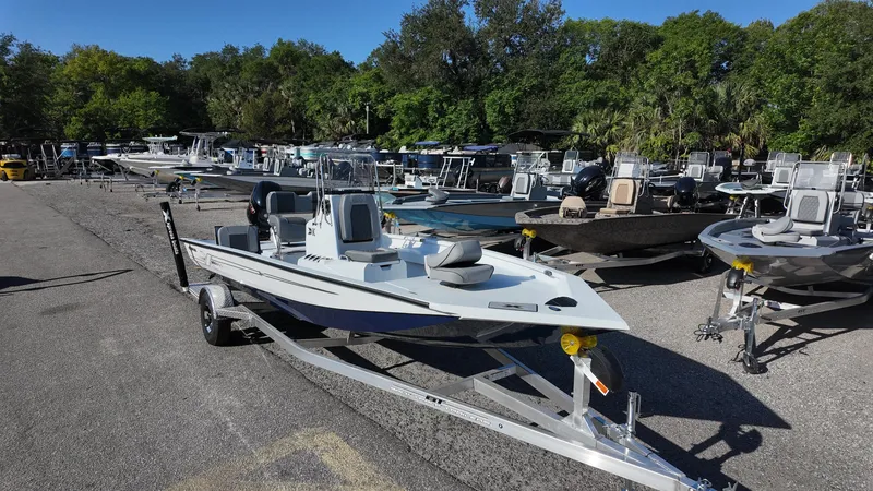 Slide: The Image of 2025 Xpress H20B boat on trailer in a marina with multiple boats. - 2
