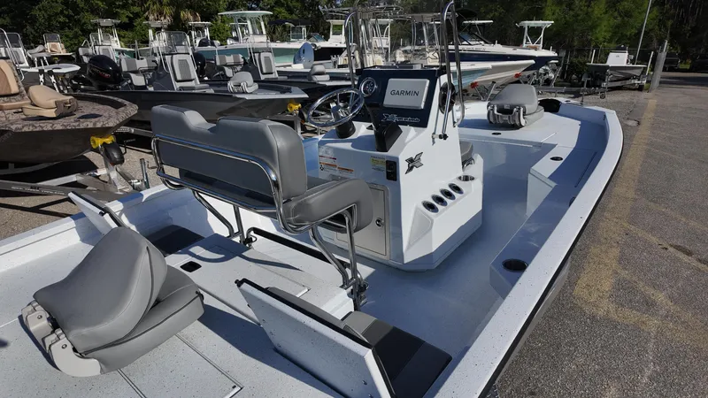 Slide: The Image of 2025 Xpress H20B boat with modern seating and navigation system, docked in a marina. - 22