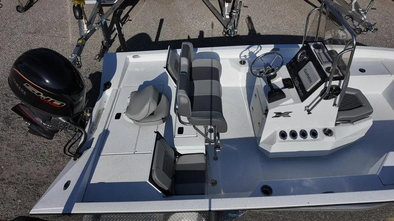Slide: The Image of 2025 Xpress H20B boat interior with seating and control console, featuring a powerful outboard motor. - 24