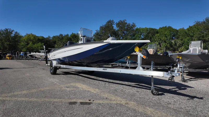Slide: The Image of 2025 Xpress H20B boat on trailer in outdoor lot, clear sky background. - 3