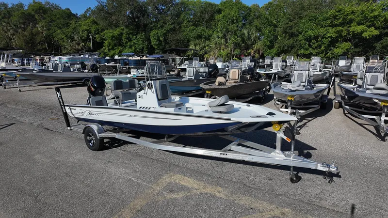 Slide: The Image of 2025 Xpress H20B boat on trailer in marina, surrounded by other boats. - 6