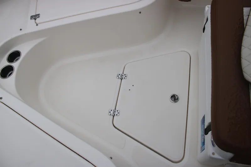 Slide: The Image of 2025 Pioneer 222 Sportfish boat interior with storage compartment and cup holders. - 10