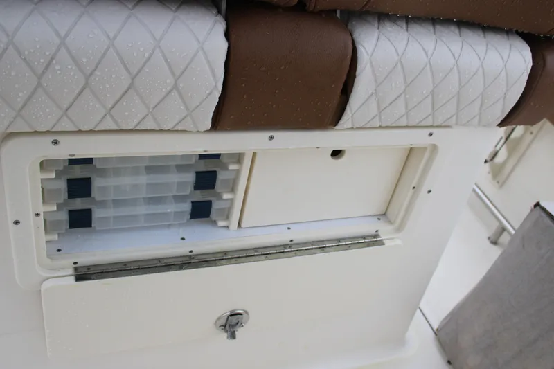 Slide: The Image of 2025 Pioneer 222 Sportfish storage compartment with cushioned seating and organized tackle boxes. - 15