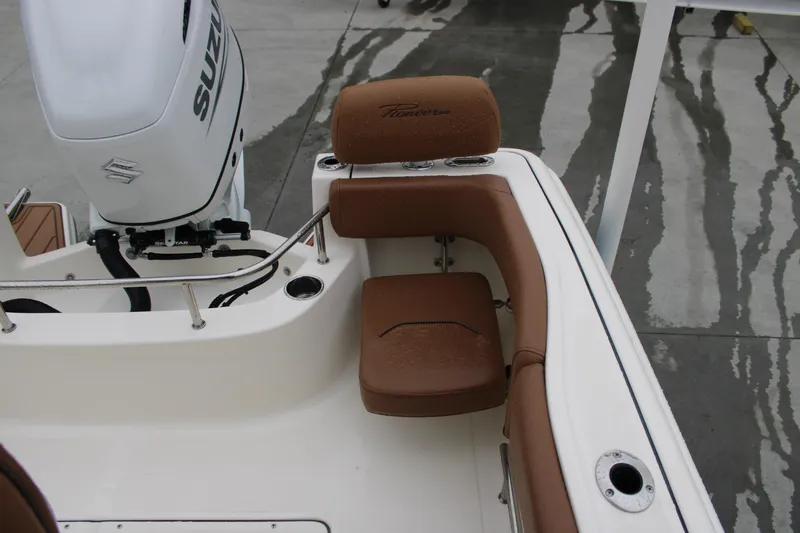 Slide: The Image of 2025 Pioneer 222 Sportfish boat with brown seating and Suzuki outboard motor. - 17