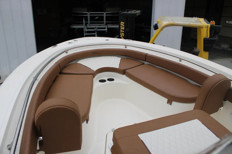 Slide: The Image of 2025 Pioneer 222 Sportfish boat interior with brown and white cushioned seating. - 4