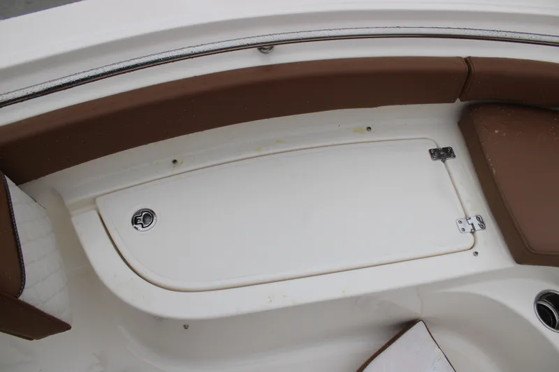 Slide: The Image of 2025 Pioneer 222 Sportfish boat interior with brown seating and storage compartment. - 5