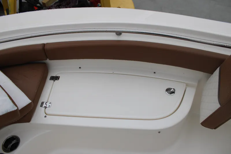 Slide: The Image of 2025 Pioneer 222 Sportfish boat interior with brown seating and storage compartment. - 7