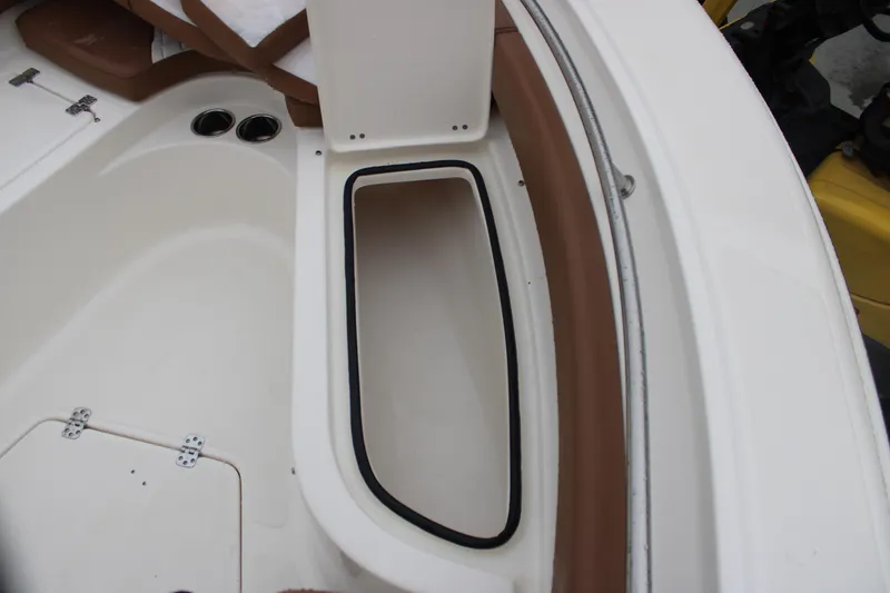 Slide: The Image of 2025 Pioneer 222 Sportfish boat interior storage compartment with brown and white design. - 8
