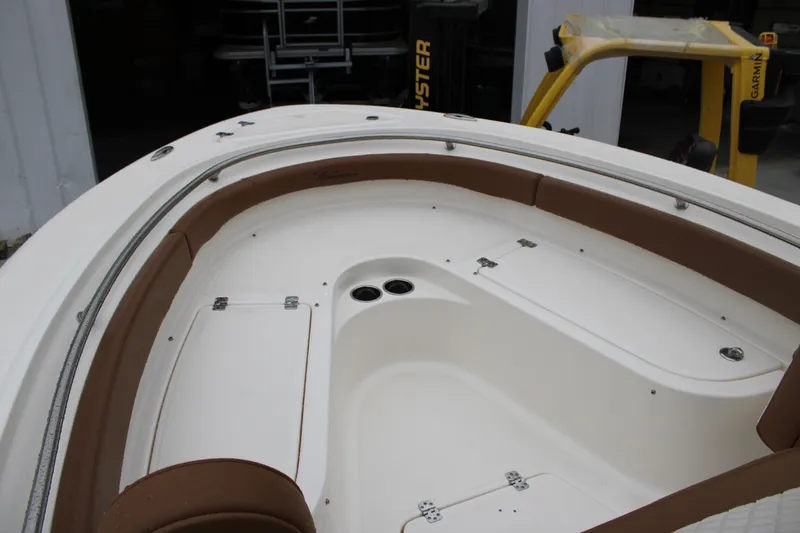 Slide: The Image of 2025 Pioneer 222 Sportfish boat interior with brown seating and storage compartments. - 9