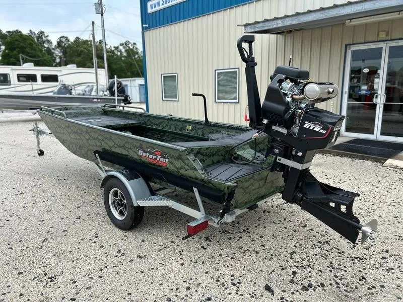 Slide: The Image of 2025 Gator Tail 1750 MID DECK SAVAGE boat on trailer, parked outside a building. - 7