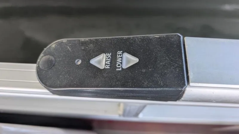 Slide: The Image of Control panel on a 2023 Sun Tracker Party Barge 20 DLX, featuring raise and lower buttons. - 10