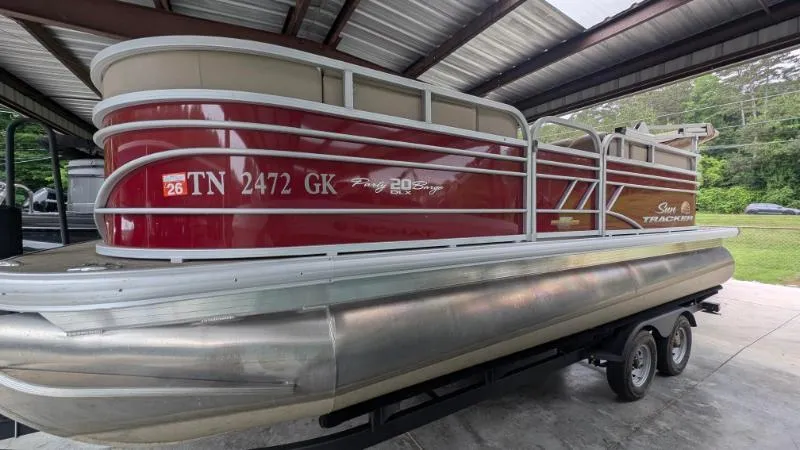 Slide: The Image of 2023 Sun Tracker Party Barge 20 DLX pontoon boat on trailer in covered storage. - 16