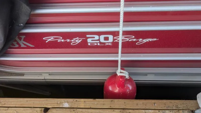 Slide: The Image of 2023 Sun Tracker Party Barge 20 DLX with red fender and rope. - 19