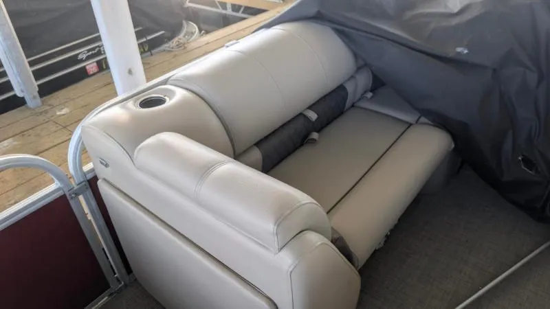 Slide: The Image of 2023 Sun Tracker Party Barge 20 DLX interior seating with cup holder, docked. - 25