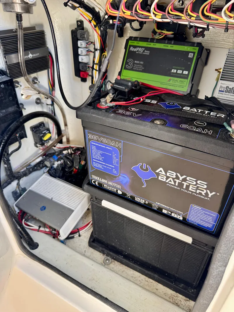 Slide: The Image of 2023 Contender 24S boat battery compartment with Abyss Battery and wiring setup. - 11