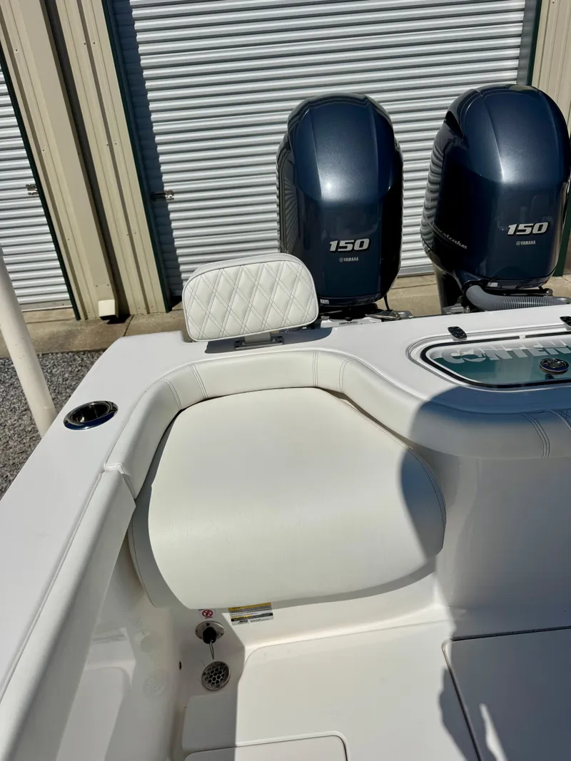 Slide: The Image of 2023 Contender 24S boat with dual 150 Yamaha engines, white seating, and storage compartment. - 14