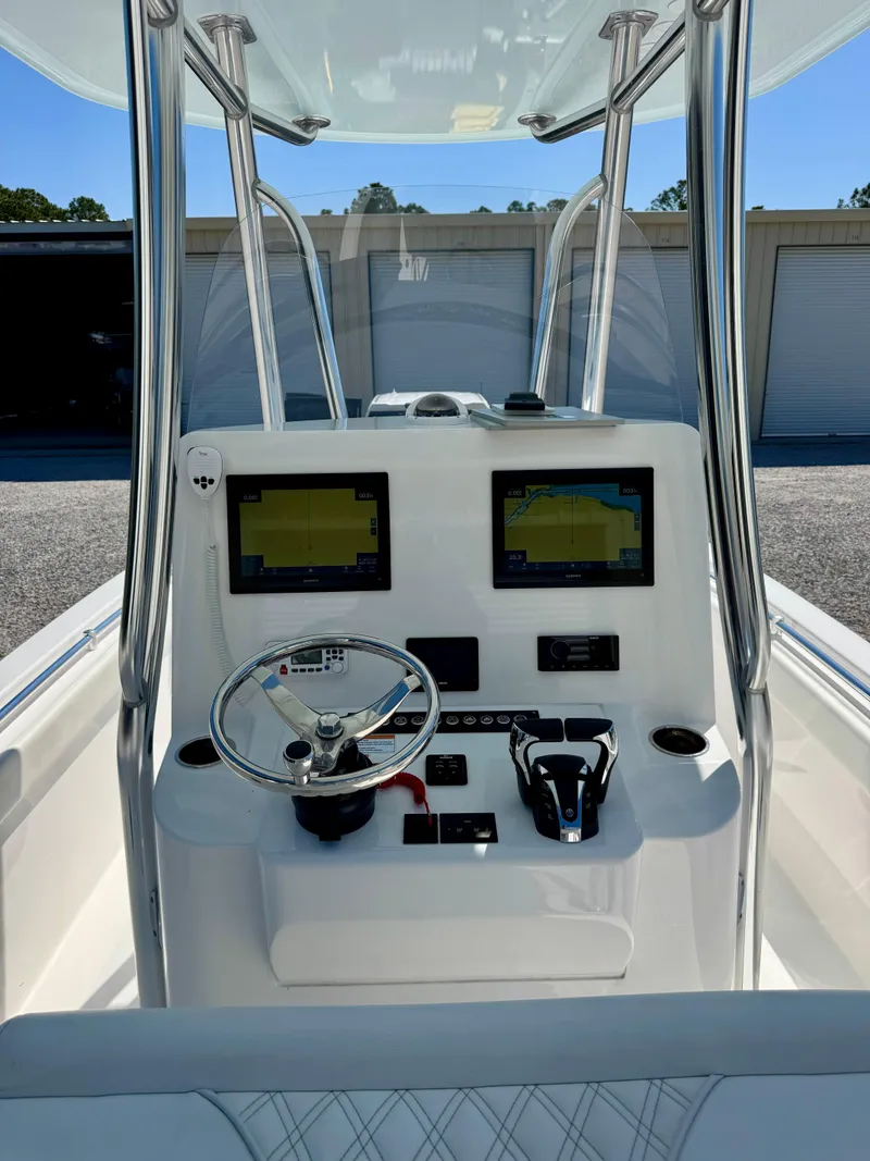 Slide: The Image of 2023 Contender 24S boat dashboard with dual screens and steering wheel. - 17