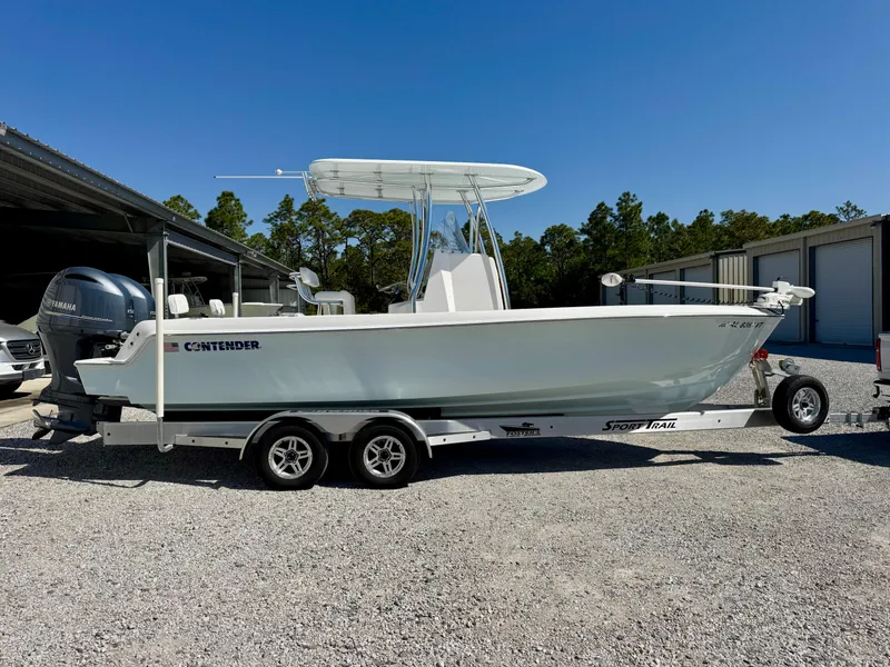 Slide: The Image of 2023 Contender 24S boat on trailer, parked outdoors, clear sky background. - 2