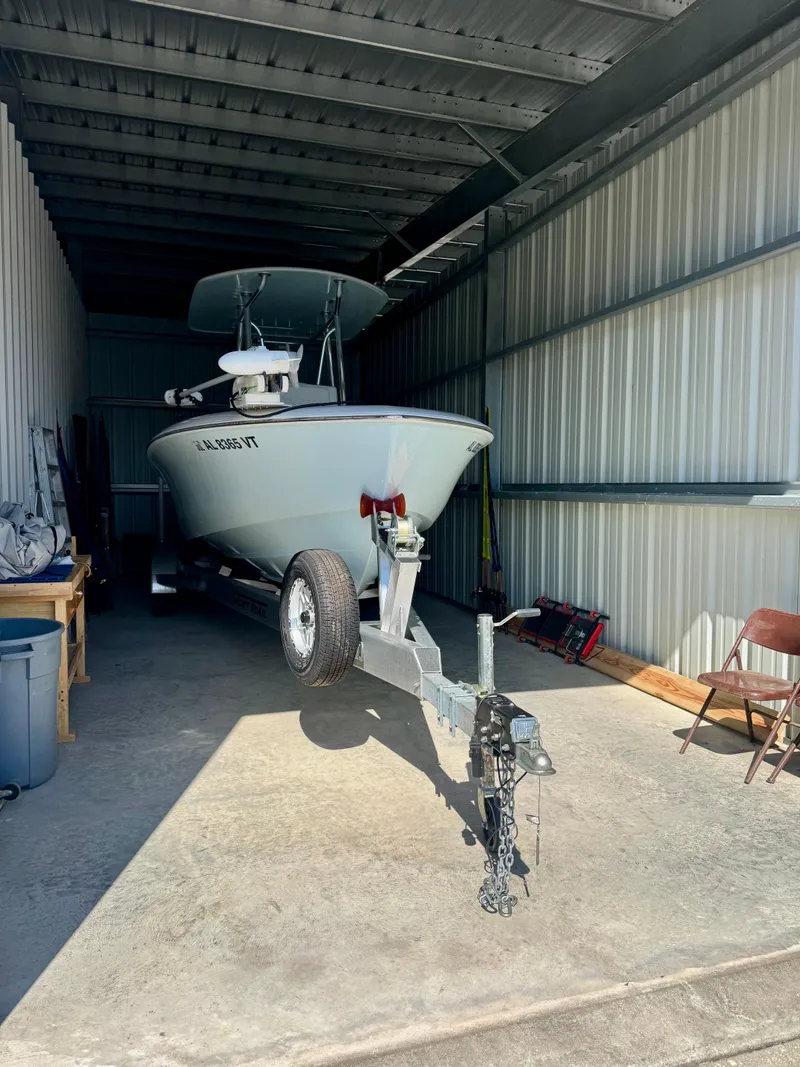 Slide: The Image of 2023 Contender 24S boat stored in a metal garage on a trailer. - 22