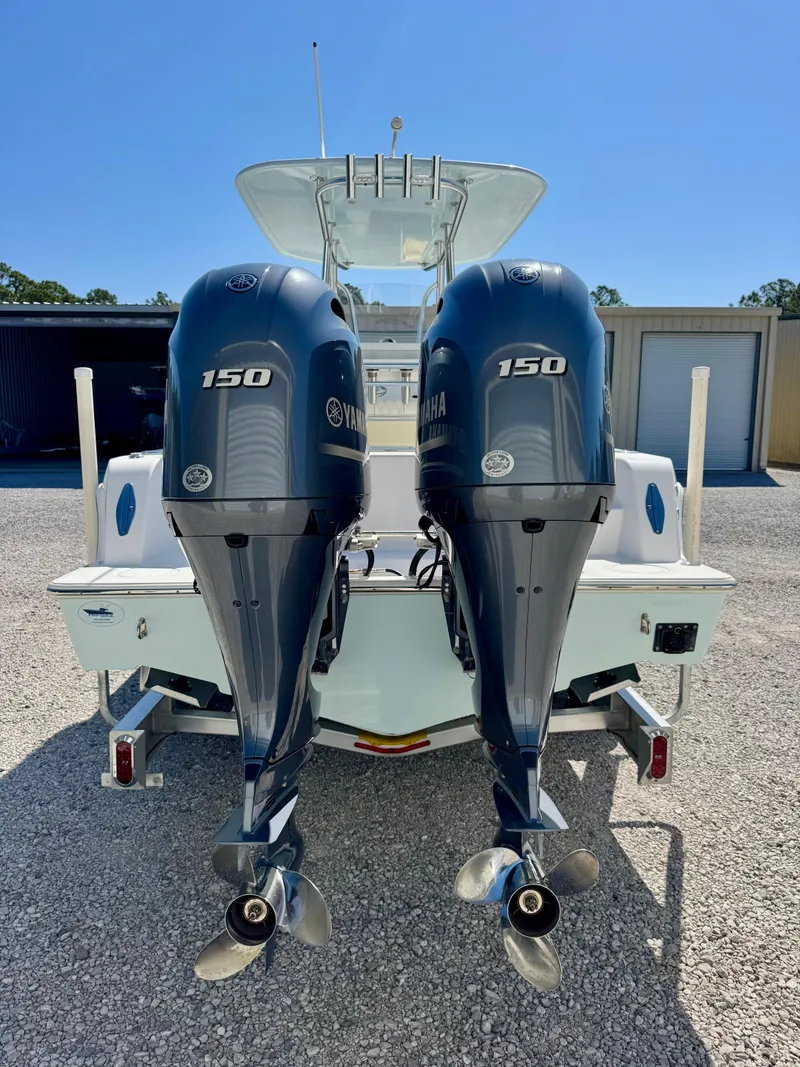 Slide: The Image of 2023 Contender 24S boat with dual Yamaha 150 outboard engines, parked on gravel. - 5