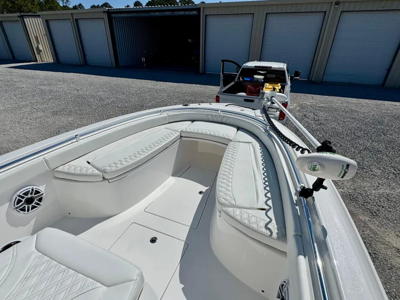 Slide: The Image of 2023 Contender 24S boat with white seating, parked near storage units. - 6