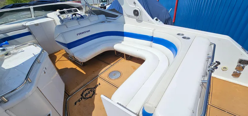 Slide: The Image of 2002 Fountain 38 Express Cruiser with white and blue seating, spacious deck, and modern controls. - 10