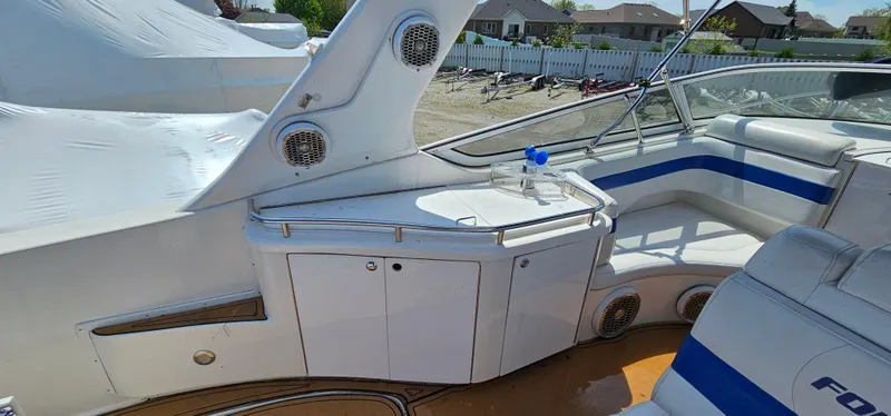 Slide: The Image of 2002 Fountain 38 Express Cruiser interior with seating and storage, featuring sleek white and blue design. - 11